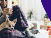 Woman holding mug with dog on lap: Symptoms of fibromyalgia