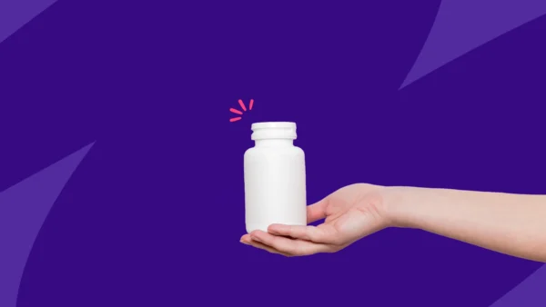 A hand holding an unlabled pill bottle: Can you buy metronidazole over the counter?