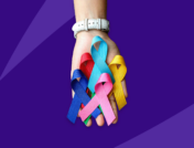 Hand holding multi-colored cancer ribbons: Navigating a cancer diagnosis