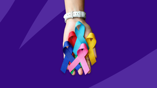 Hand holding multi-colored cancer ribbons: Navigating a cancer diagnosis