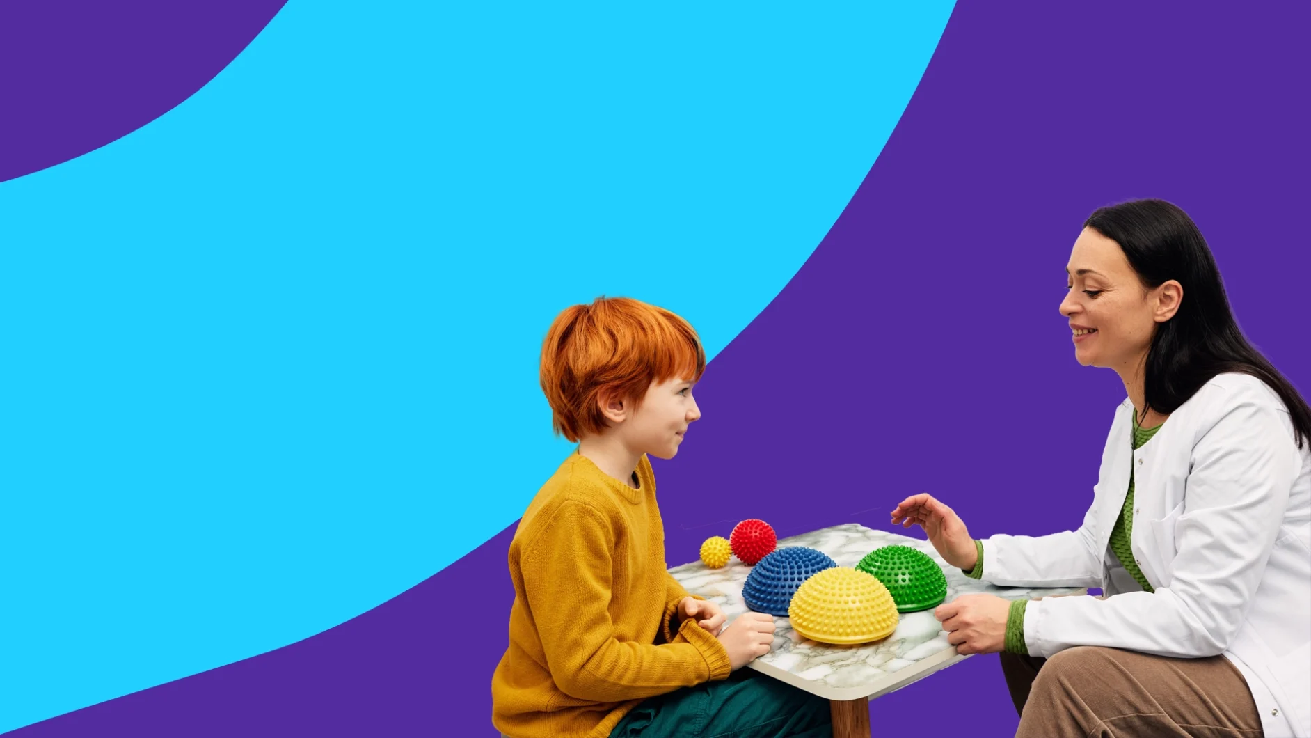 A child and a doctor at a table with sensory items