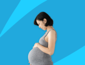 A pregnant person looking down at her belly: Can you take Aimovig while pregnant"