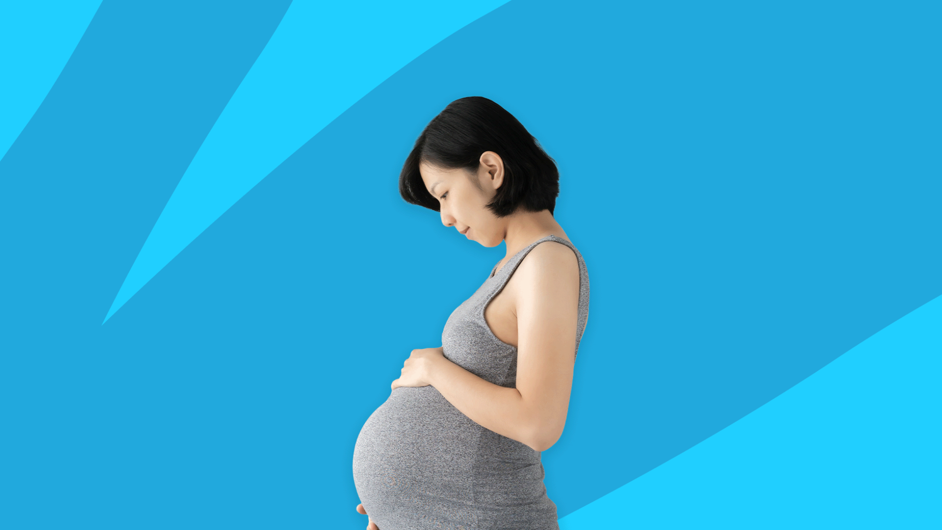 A pregnant person looking down at her belly: Can you take Aimovig while pregnant"