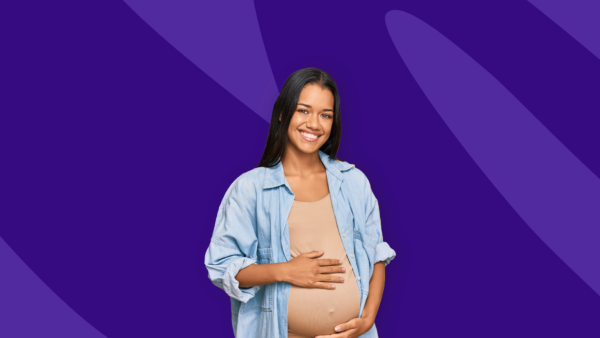 A person smiling, holding their belly: Can you take Rexulti while pregnant?