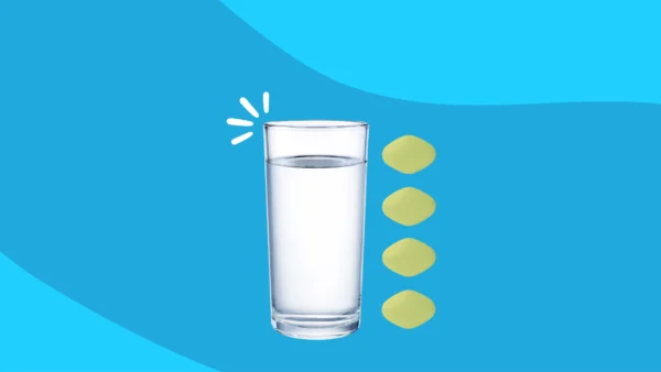 glass of water next to tablets - how much water should you drink when taking Farxiga